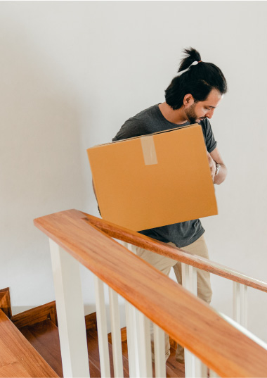 a person is moving a moving box down the stairs